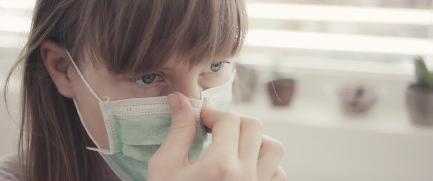 Woman put on surgical face mask staying home during coronavirus covid 19 virus outbreak close up