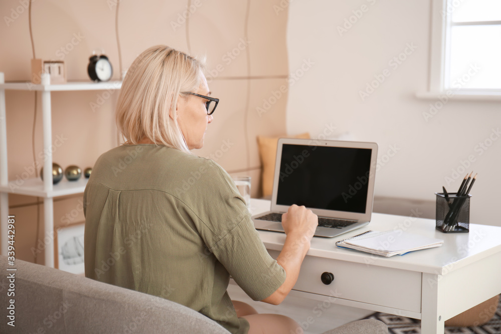 Canvas Prints Mature woman using laptop for online learning at home