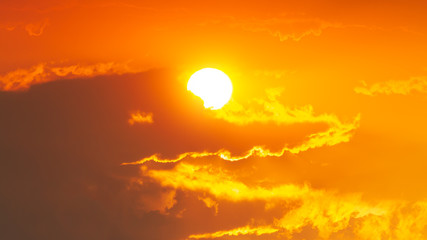 Dark clouds look like a crocodile with the sun and the orange sky.