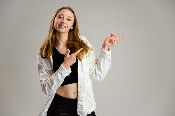Fototapeta na wymiar Portrait of a happy caucasian girl with smile in a white jacket on a gray background
