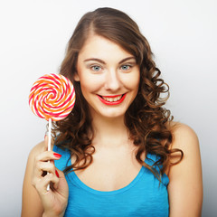 Funny curly woman holding big lollipop.