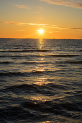 Fototapeta premium Beautiful orange sunset at sea. Sunlight shining over water