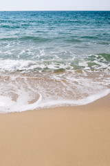 Fototapeta na wymiar Calm Waves Washing Over a Beach on a Sunny Day