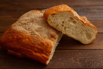 freshly baked loaf of bread sliced on a wooden table, still life