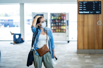 Traveler with mask stuck in airport no able to return home country due to COVID-19 border closures.