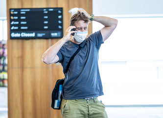 Traveler with mask stuck in airport no able to return home country due to COVID-19 border closures.