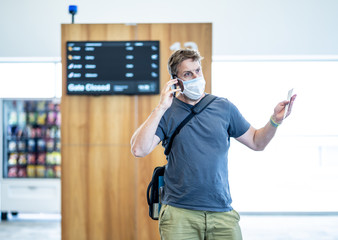 Traveler with mask stuck in airport no able to return home country due to COVID-19 border closures.