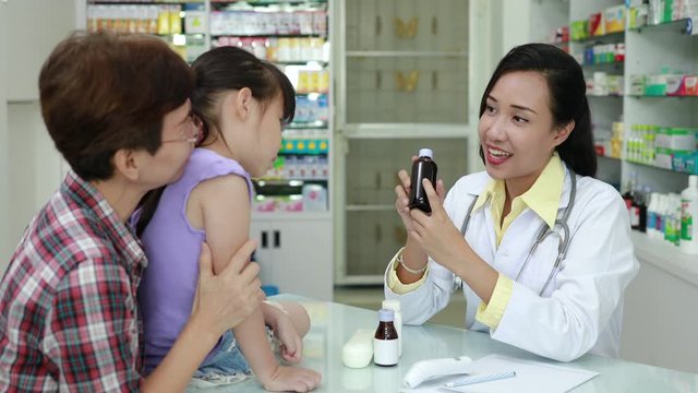Asian female Pharmacist explained talking details of the drug to patient in pharmacy store Thailand 4k video