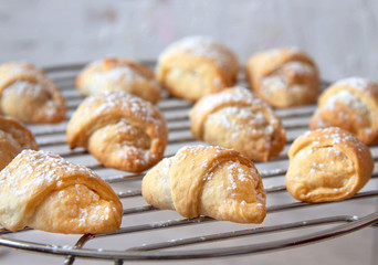 Homemade mini croissants on a cooling rack. Confectionery menu concept