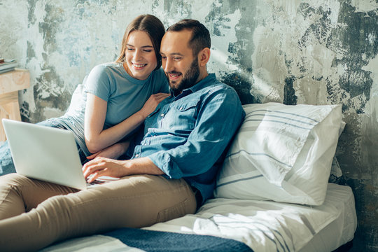 Beautiful young couple watching films together at home stock photo