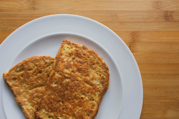 Eggy Bread or French Toast served on a crisp white round plate against a bamboo wooden background