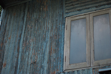 Obraz na płótnie Canvas Rusty zinc sheet wall with old wooden window background