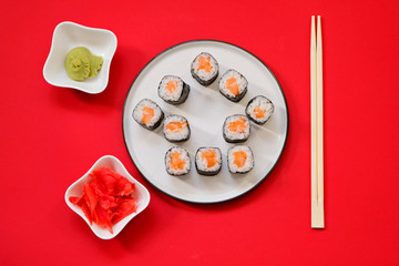 House shape sushi rolls on red background with copy space. Ordering sushi online at home while quarantine