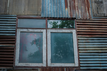 Rusty zinc sheet wall with old wooden window background