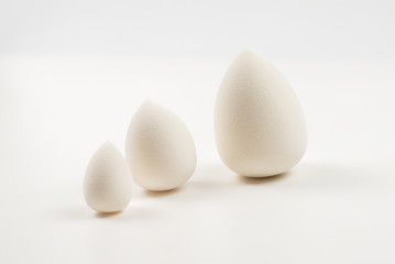Small, medium and large  white beauty blender isolated.