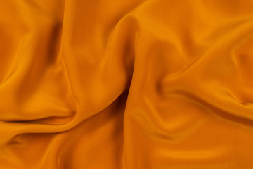 Golden silk or satin luxury fabric texture can use as abstract background.