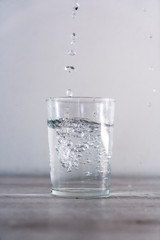 Large drops of water in a glass of water. High speed drink macro photography