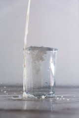 Throwing milk from above into a glass of water on a white background. Drink macro photography