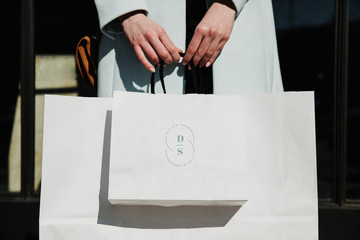 Woman carrying a minimal paper bag