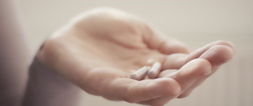 Woman hold pills in hand staying home during coronavirus covid 19 outbreak unrecognizable extreme close up