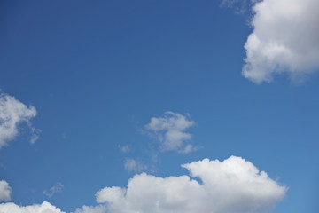 The sun shines through the cumulus clouds in the blue sky. Background and texture for artists and design. Bright light in the eyes. Water in gaseous state. The circulation of fluid in nature