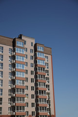 Lviv, Ukraine - 3 4 2020: Facade of a tall multi-storey modern house with balconies and large glass windows. Design of modern architecture. Top view from the bottom. Modern city architecture