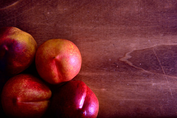 Fototapeta na wymiar Red and yellow Nectarine on a wooden table