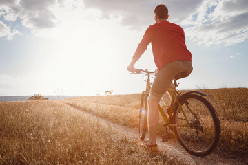 handsome man traveling with bicycle in sunset, healthy active lifestyle traveler