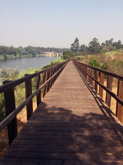 wooden footbridge in perspective on the river bank