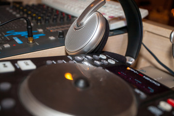 Fototapeta na wymiar Closeup of an audio mixing control panel, dj equipment, with headphones. Dj Music club life concept