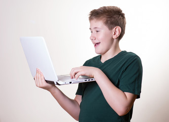 excited 10 - 12 years old boy (teenager) use his laptop