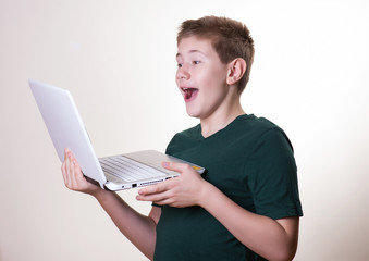 excited 10 - 12 years old boy (teenager) use his laptop