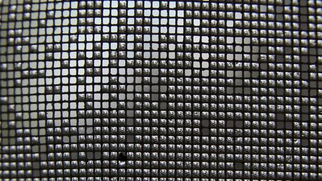 wet air conditioning grid with water droplets flowing down it, macro video