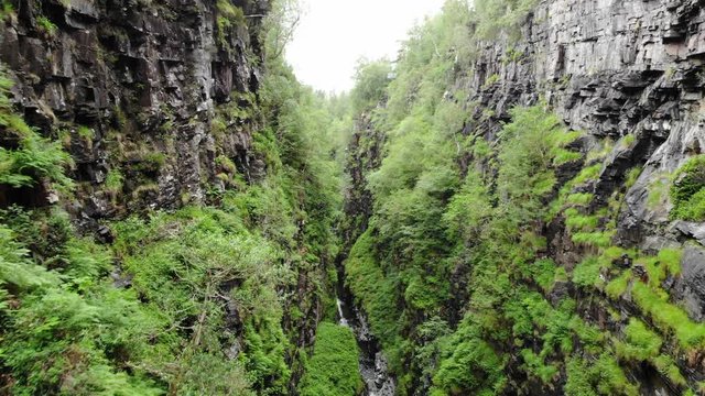 An aerial shot of a very narrow deep valley in Garve, near Auchindrean in Northern Scotland a pannin ghost moving forward to show the valleys scale. Captured during ht North Coast 500 (NC500)