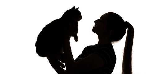 silhouette of a cute girl with long hair and cat in her arms, a young woman hugs a pet on a white isolated background
