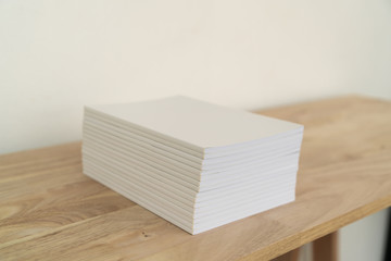 Blank catalog, magazines, book on wood background.