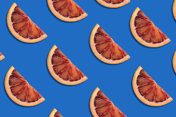 abstract fruit summer background. pattern of red orange slices on blue background