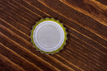 bottom view of a metal cork with copyspace isolated on a wooden background. Cover blank cap on wood table, canned meal