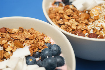 Handmade Bowl healthy tasty breakfast of yogurt, smoothie with granola, nuts, bananas and berries