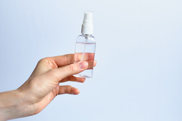 Hand holds sanitizer antiseptic on a white background - concept of protection against coronavirus COVID-19.