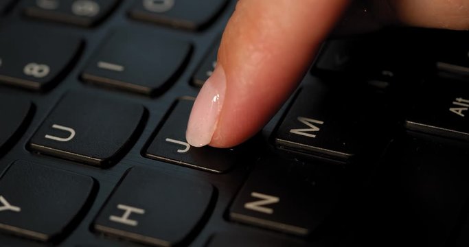 Pushing J button on the black keyboard. English letters. Used Macro lens and slow-mo.