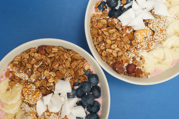 Handmade Bowl healthy tasty breakfast of yogurt, smoothie with granola, nuts, bananas and berries