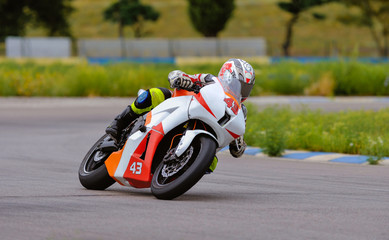 Motorcycle practice leaning into a fast corner on track