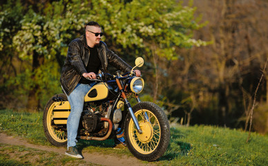 Fototapeta na wymiar Biker leaning on a motorcycle enjoying the view