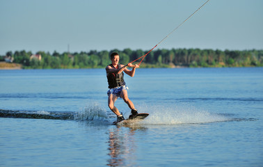 the guy is riding a wakeboard on the river. Active and Extreme Sports