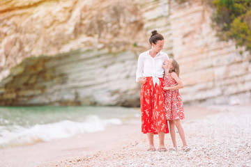 Beautiful mother and daughter at the beach enjoying summer vacation.