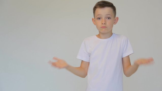 Disappointed boy in white t-shirt waving arms on white background.