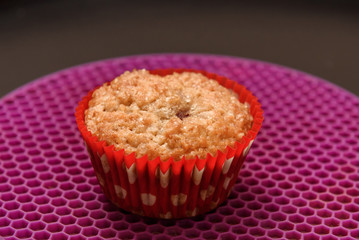 Home baked muffin at red paper form.