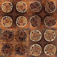 Four kinds of wooden handmade amulets what turned in all directions. All are in brown colour.