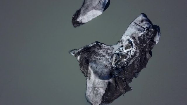 Calved glacier ice floating in muddy murky river waters, near Fairbanks, Alaska, aerial orbit right